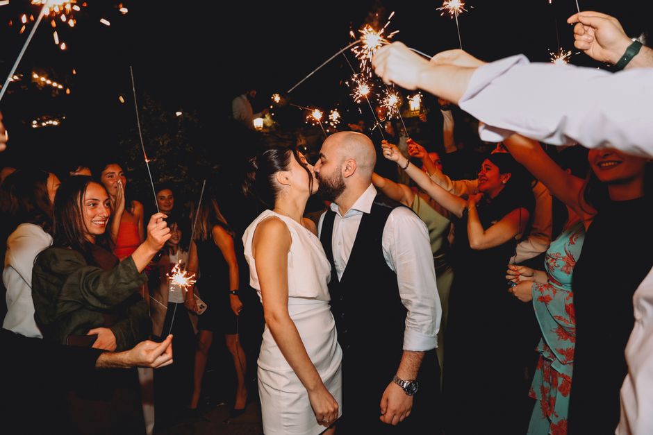 Bride and groom celebrating with sparklers at dusk